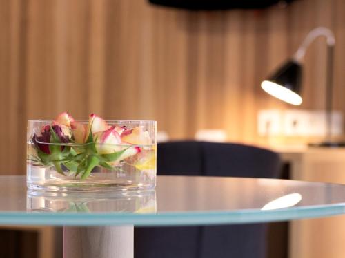 a glass vase with flowers on a glass table at Brauerei_Gasthof Pfister in Eggolsheim