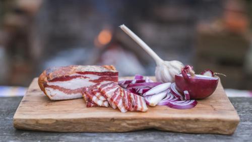 a cutting board with a sandwich and onions and a spoon at Old Chestnut Vacation Home in Varaždinske Toplice