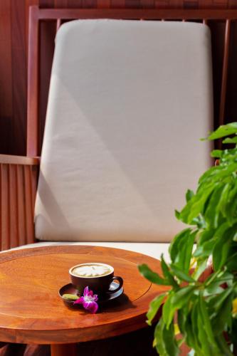 a cup of coffee and a flower on a table at Orchid Premium Cruise in Ha Long