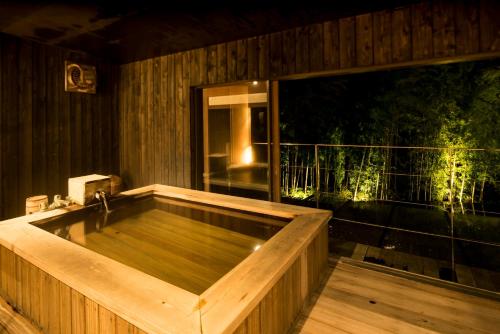 una vasca da bagno in legno situata sulla terrazza di Kinnotake Sengokuhara(Adult Only) a Hakone