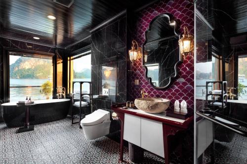 a bathroom with a tub and a toilet and a sink at Orchid Premium Cruise in Ha Long