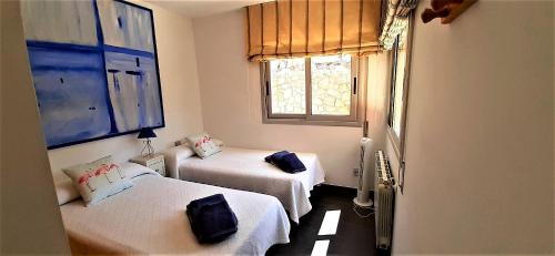 ein Zimmer mit zwei Betten und einem Fenster in der Unterkunft Villa Mur - Espectacular villa cerca de Sitges y BCN in Olivella