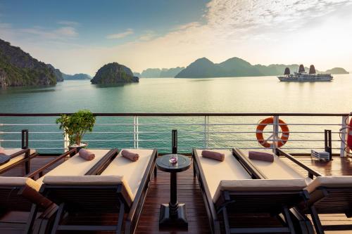 a boat deck with tables and chairs on the water at Orchid Premium Cruise in Ha Long