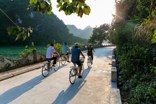 a group of people riding bikes down a road at Orchid Premium Cruise in Ha Long