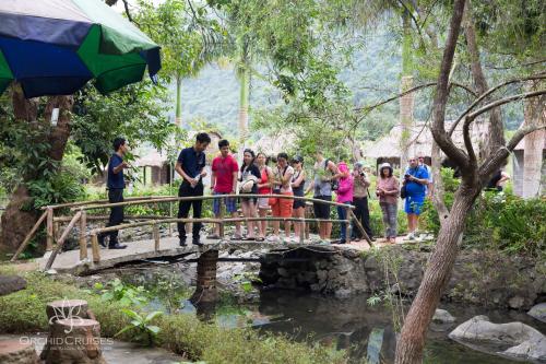 a group of people standing on a bridge over a stream at Orchid Premium Cruise in Ha Long