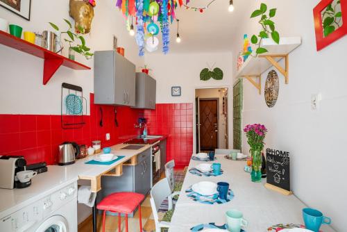 a kitchen with red walls and white counters at KAZIMIERZ-GOOD VIBES APARTMENT for 7 people! in Krakow