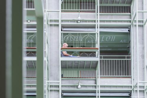 a man looking out from a window of a building at Samsen Street Hotel in Bangkok