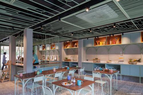 a restaurant with tables and chairs in a room at Samsen Street Hotel in Bangkok
