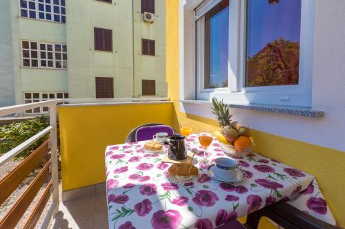 a table with a plate of food on a balcony at LUKA in Crikvenica