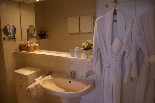 a white bathroom with a sink and a toilet at Ferienwohnung Am Hylligen Born in Bad Pyrmont