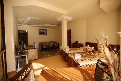 una gran sala de estar con 2 camas y una mesa. en Jermuk Ani Hotel, en Jermuk