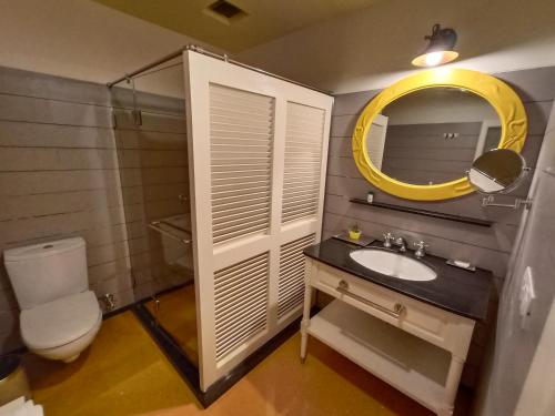 a bathroom with a sink and a mirror and a toilet at Hotel Pine Retreat Mallroad in Mussoorie