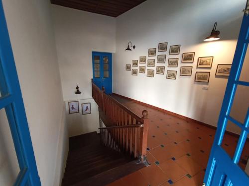 a staircase with a blue door and pictures on the wall at Hotel Pine Retreat Mallroad in Mussoorie