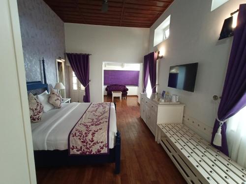a bedroom with a large bed and a television at Hotel Pine Retreat Mallroad in Mussoorie