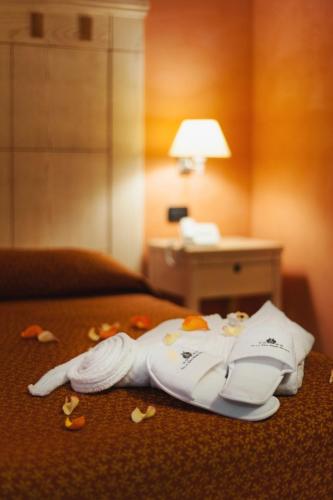 a pile of towels on a bed in a hotel room at Villa Zina Family Resort in Custonaci