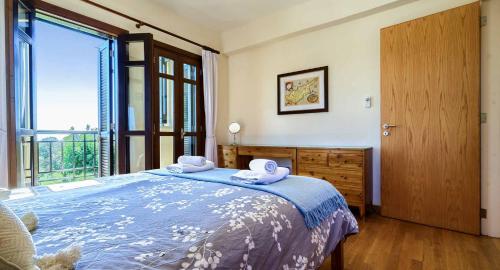Un dormitorio con una cama y una ventana grande. en 1 bedroom Apartment Nesoi with sea and golf views, Aphrodite Hills Resort, en Kouklia