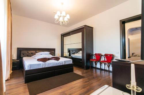 a bedroom with a bed with a mirror and red chairs at Residence Riverside in Galaţi