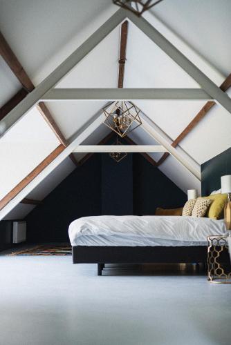 a bedroom with a bed in an attic at The Annex Retreat - a luxury countryside villa in Geysteren