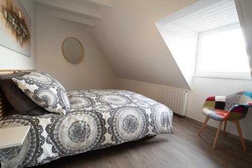 a bedroom with a bed and a chair at Le rohan sawadee in Colmar