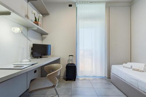 a hotel room with a bed and a desk at Camplus Guest Bononia Casa per Ferie in Bologna