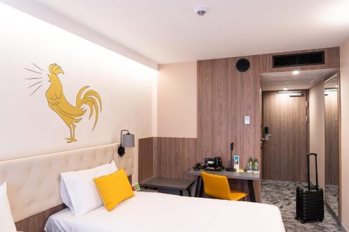 a hotel room with a bed with a rooster on the wall at ibis Styles Lublin Stare Miasto in Lublin