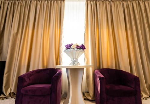 two chairs and a table with a vase of flowers at Residence Riverside in Galaţi