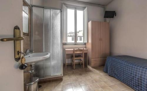 baño con lavabo, cama y ventana en Hotel Aldobrandini en Florence