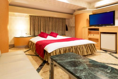 a hotel room with a bed and a flat screen tv at Hotel Route One in Osaka