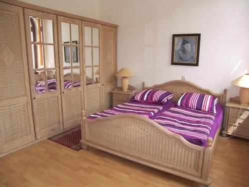 um quarto com uma cama grande e lençóis roxos em Haus Lucie em Heringsdorf