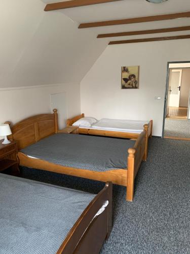 a bedroom with two beds and a mirror at Penzion Na Bobrovníku in Lipova Lazne