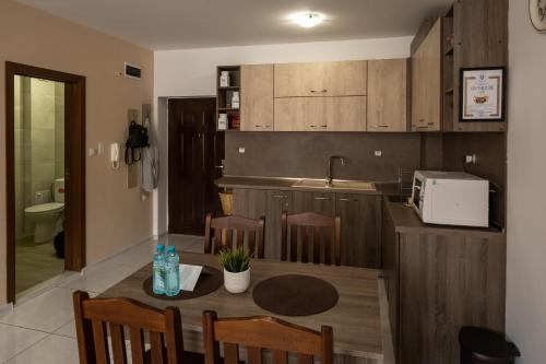 eine Küche mit einem Tisch mit Stühlen und einem Waschbecken in der Unterkunft Luxor Apartment in Welingrad