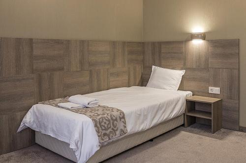 a bedroom with a large bed with white sheets at Семеен Хотел Естило in Dimitrovgrad