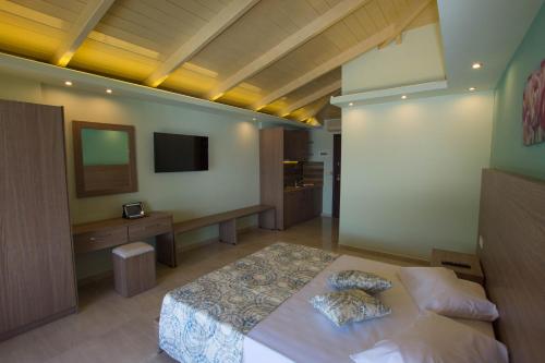 una camera con un grande letto e una TV di Koukis club a Vasilikós