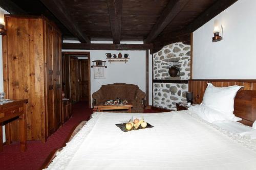 ein Schlafzimmer mit einem großen weißen Bett in einem Zimmer in der Unterkunft Family hotel Makedonska Kruchma in Dobrinischte