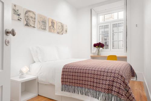 een witte slaapkamer met een bed en een raam bij Host Wise - Oporto Classic Apartment in Porto