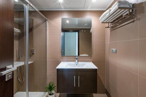 a bathroom with a sink and a mirror and a shower at Apartment front Line La Cala Golf Resort in La Cala de Mijas