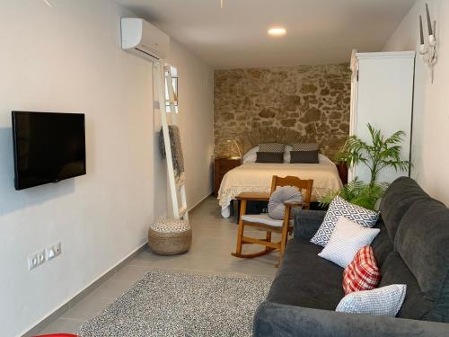 sala de estar con sofá y cama en TRIPERIA 25 en Medina Sidonia
