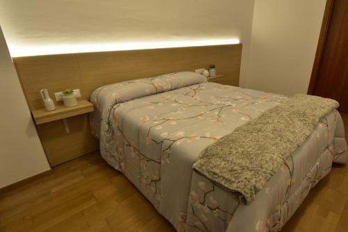 1 dormitorio con cama y mesita de noche con cama sidx sidx en Apartament Gredera, en Olot