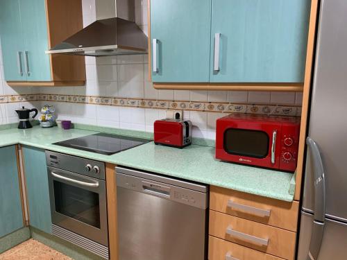 uma cozinha com um micro-ondas vermelho no balcão em Apartamento Sanchiz em Monóvar