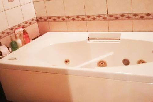 a white bath tub sitting in a bathroom at Hotel Route One in Osaka