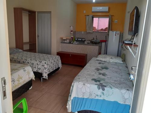 um quarto de hotel com duas camas e uma cozinha em Recanto Cruzeiro em Barreirinhas