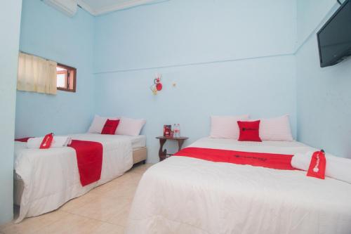 A bed or beds in a room at RedDoorz near Pantai Boom