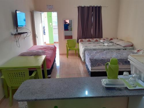 um quarto com duas camas, uma mesa e cadeiras em Recanto Cruzeiro em Barreirinhas