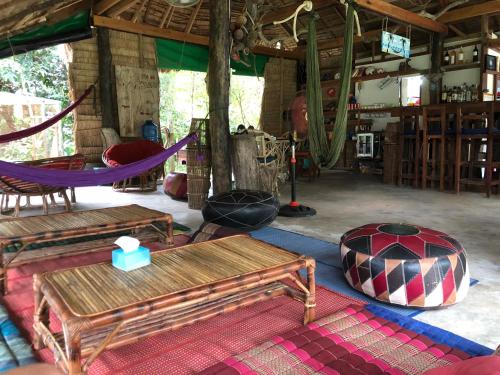 a room with a hammock and tables and chairs at Lazy Bones in Koh Rong Sanloem