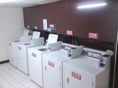 a row of washers and dryers in a room at 嵐茵鐵道旅館 in Tainan