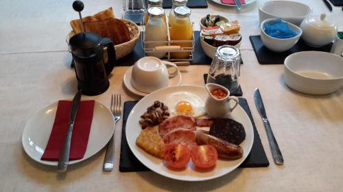 un tavolo con un piatto di prodotti per la colazione di The School House a Warrington