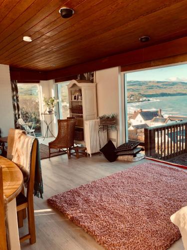 a living room with a large window with a view at Ballygally Seaview Cottage in Larne