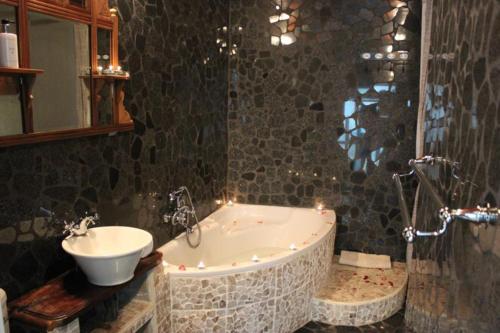a bathroom with a bath tub and a sink at La Vue Guesthouse in Lanseria