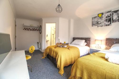 a bedroom with two beds with yellow blankets at 4 Dbl Beds, Modern Apartment, Free Parking and Home-from-home in Wakefield