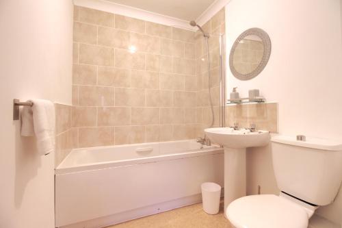een badkamer met een bad, een wastafel en een toilet bij Central, Stylish 2-bed Apartment, with allocated parking in Wakefield